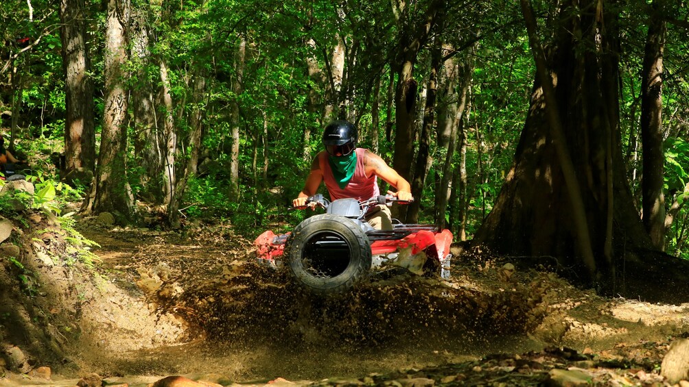 ATV rider goes through mud puddle