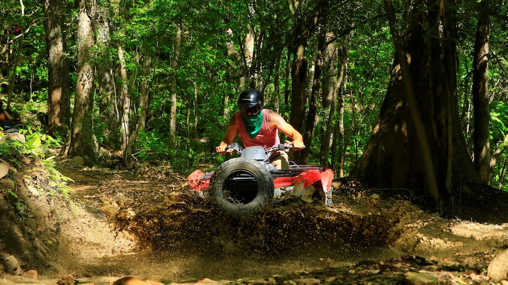ATV rider goes through mud puddle