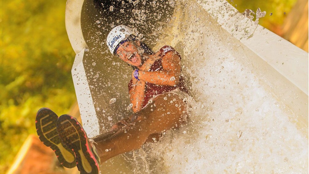 Woman rides down a waterslide in a tropical forest near Puerto Vallarta