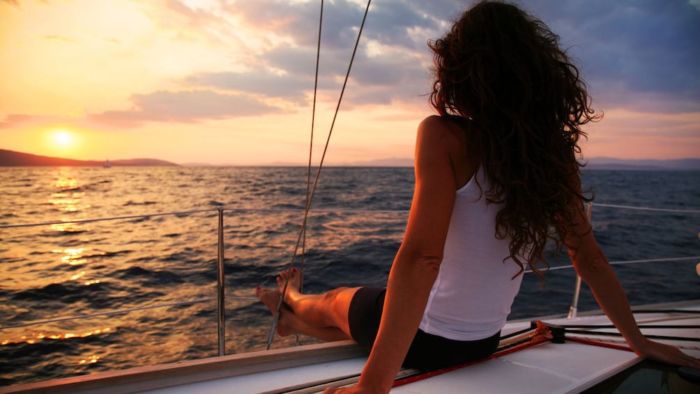 Woman enjoying the sunset from the vantage of a luxury sailboat