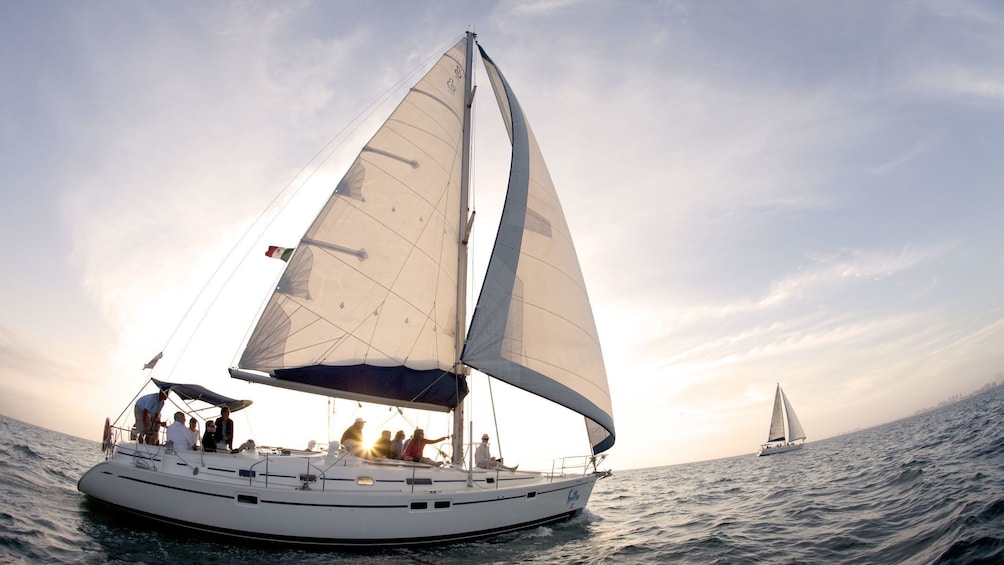 Sun sets over Banderas Bay as guests enjoy the view from a luxury sailboat