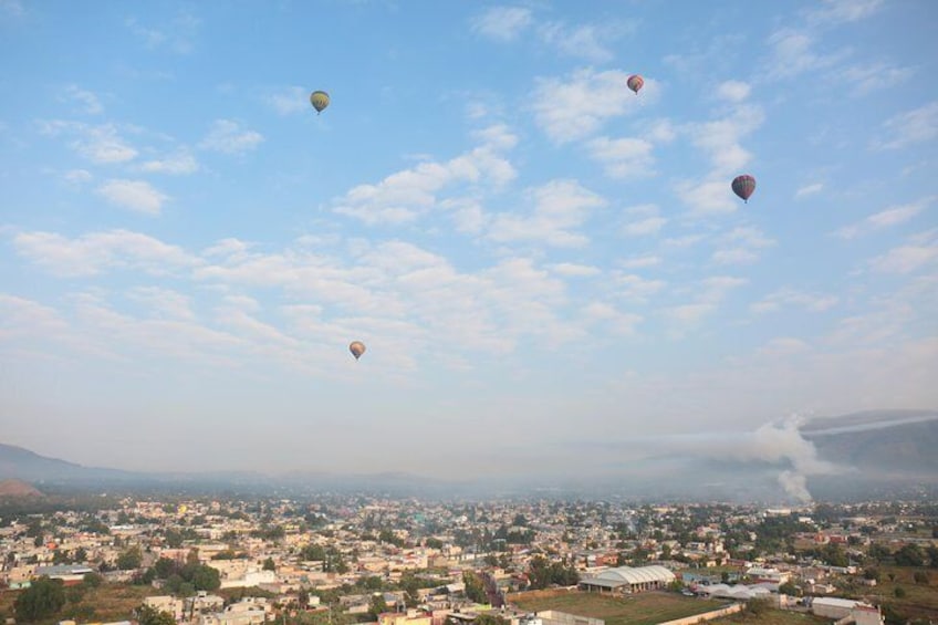Hot-air balloons drift through the sky from Mexico City to Teotihuacan archaeological site.