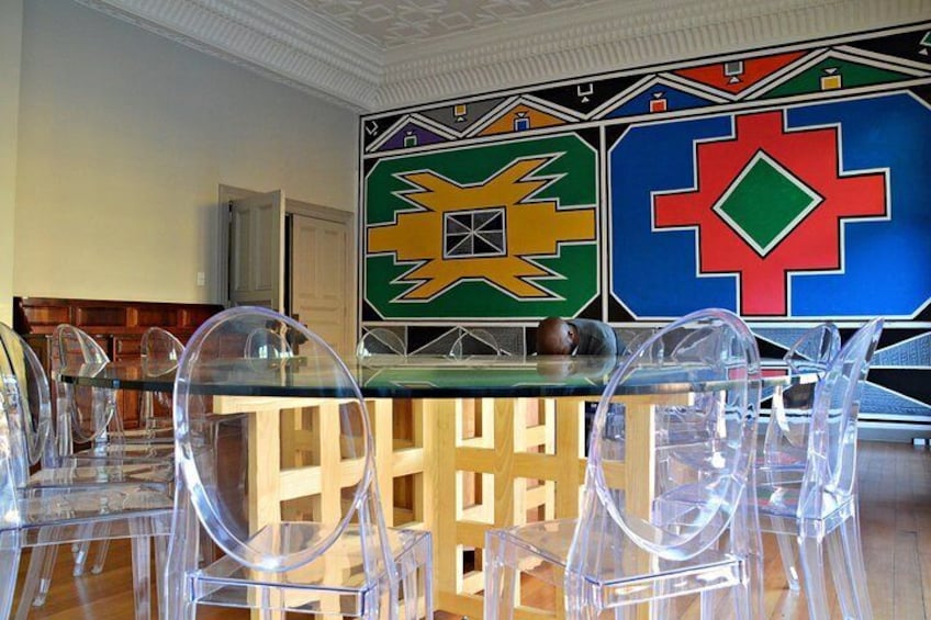 The famous expensive glass table in a room personally painted by famous Ndebele artist, Esther Mahlangu