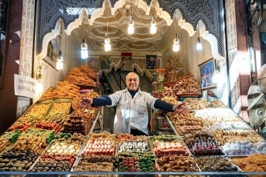 Man presenting his shop with delicious baklavas located in old town of Marrakech
