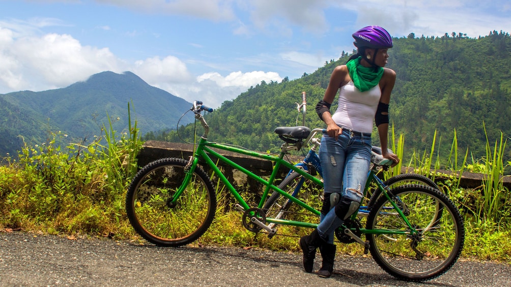 Woman leaning on a bicycle in the blue mountains of jamaica 
