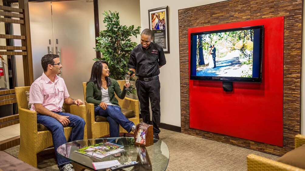 Couple having drinks watching tv at VIP Mobay Lounge in Jamaica 