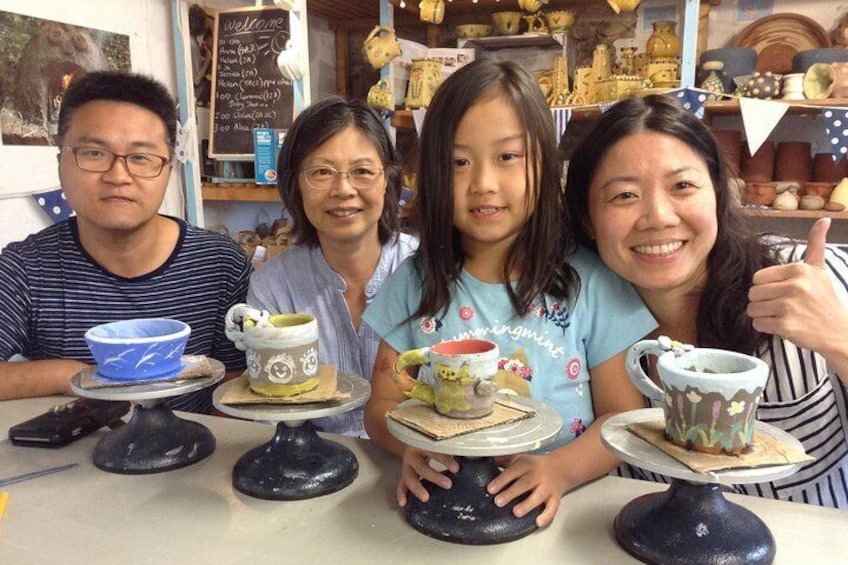 Family make pots on the wheel and decorate with coloured paints