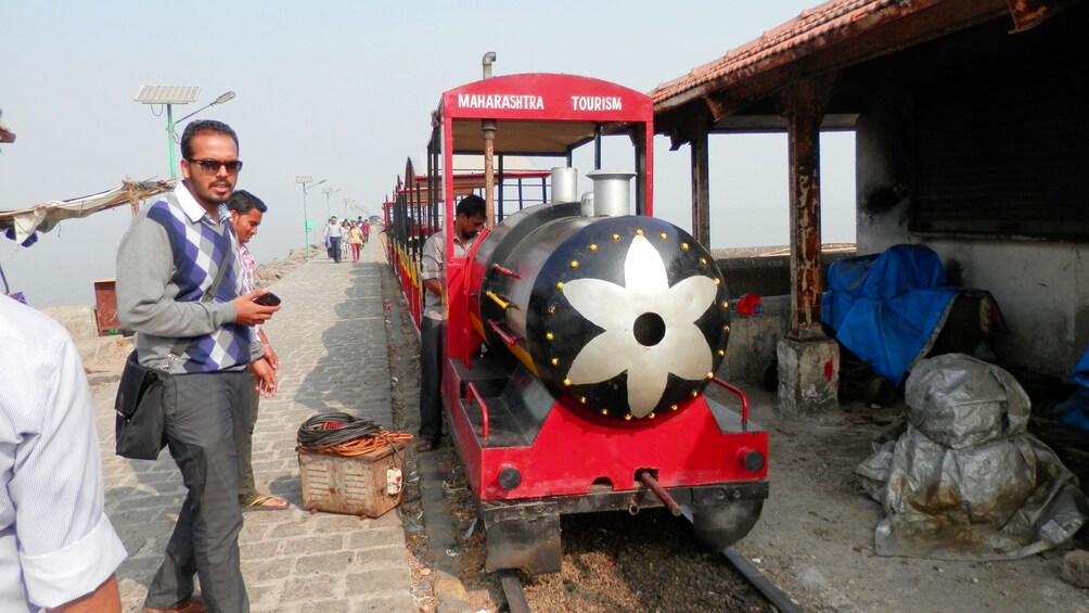 a train pulling in to a station at mumbai harbor