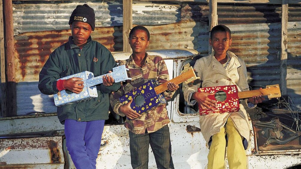 Young street musicians play homemade guitars in Soweto South Africa