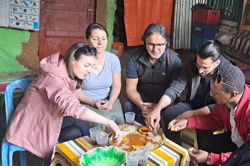 Visitors tasting Ethiopian food with tour guide Muluken