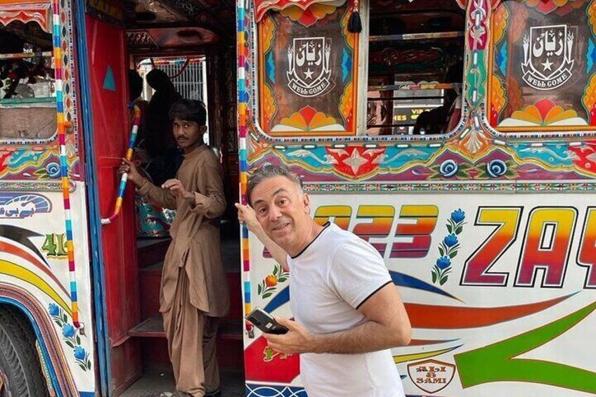 One of our clients posing in front of Karachi colorful buses 