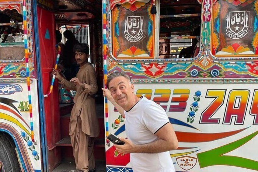 One of our clients posing in front of Karachi colorful buses