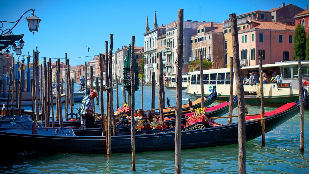 Gondolas parked along a transit terminal awaiting passengers in Venice.