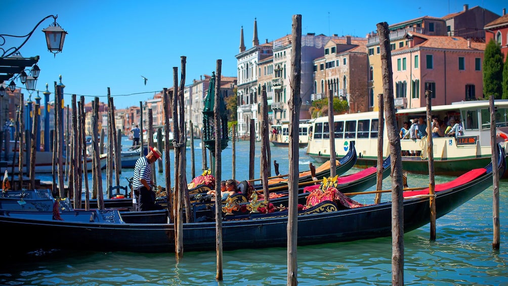 Gondolas parked along a transit terminal awaiting passengers in Venice.