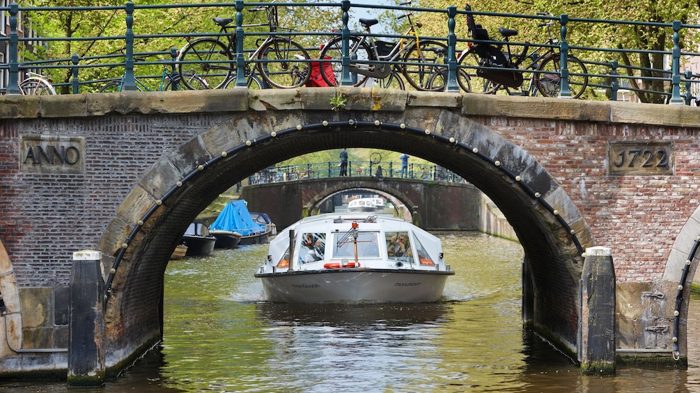 Åpne bilde 5 av 8. Cruise boat under bridge on canal in Amsterdam