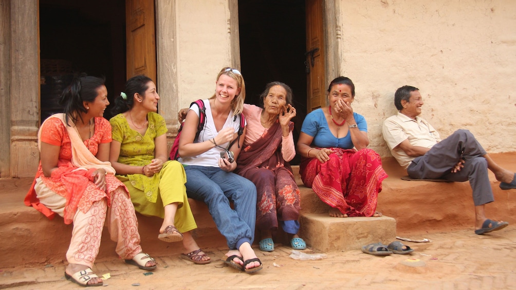 Show item 2 of 10. A woman talking with locals in Bhaktapur