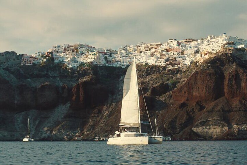 Catamaran Sailing At Santorini's Caldera