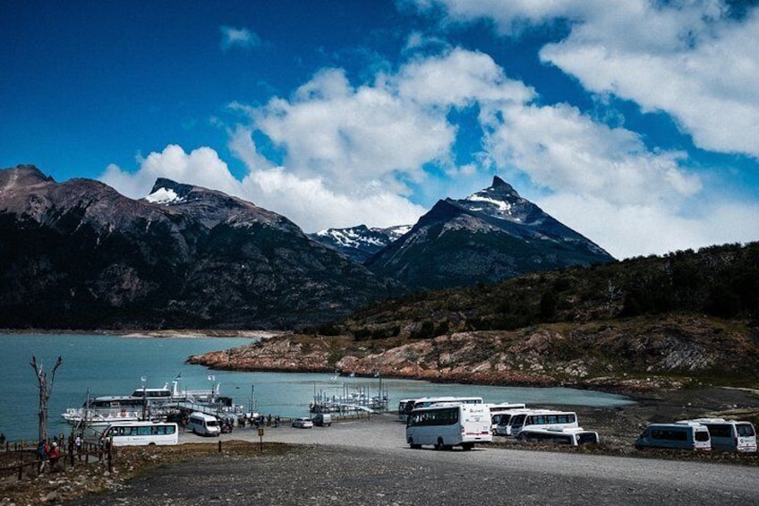 Surrounded by forests and mountains, explorers gather at the dock to join a unique glacier cruising experience.