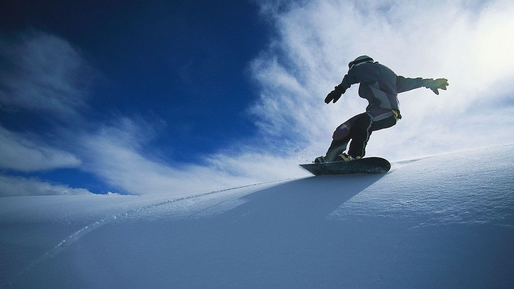 Man snowboarding down the slopes of Banff