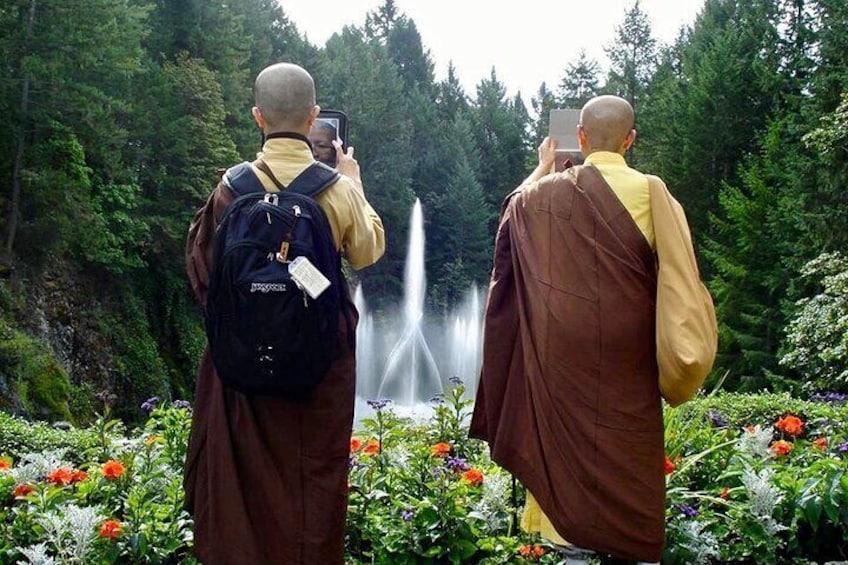 Two monks taking a picture in Butchart Gardens