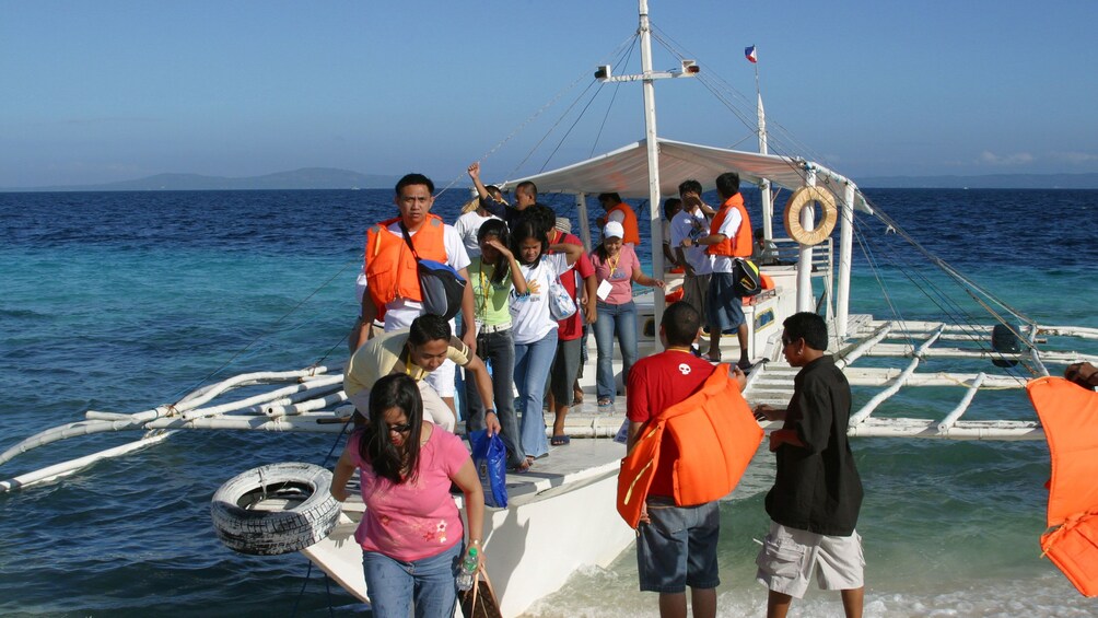 Group of boat passengers landing on the beach in Bohol
