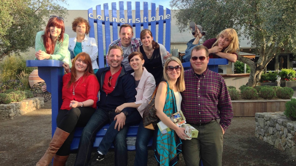 Group of people posing for a photo on a giant chair in Sonoma valley