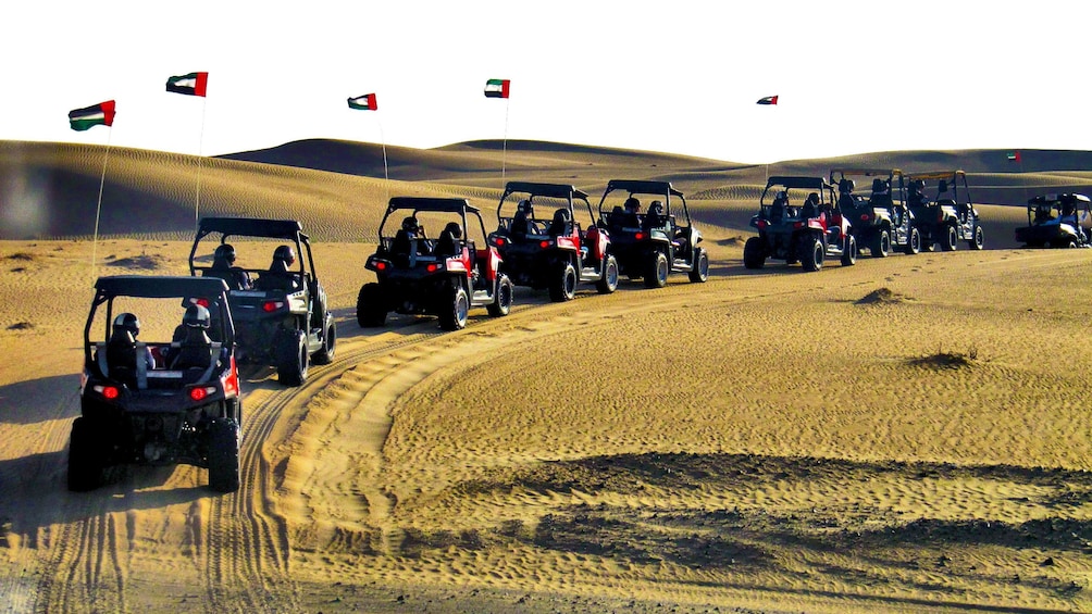 sandy buggies driving in line on sandy path in Dubai