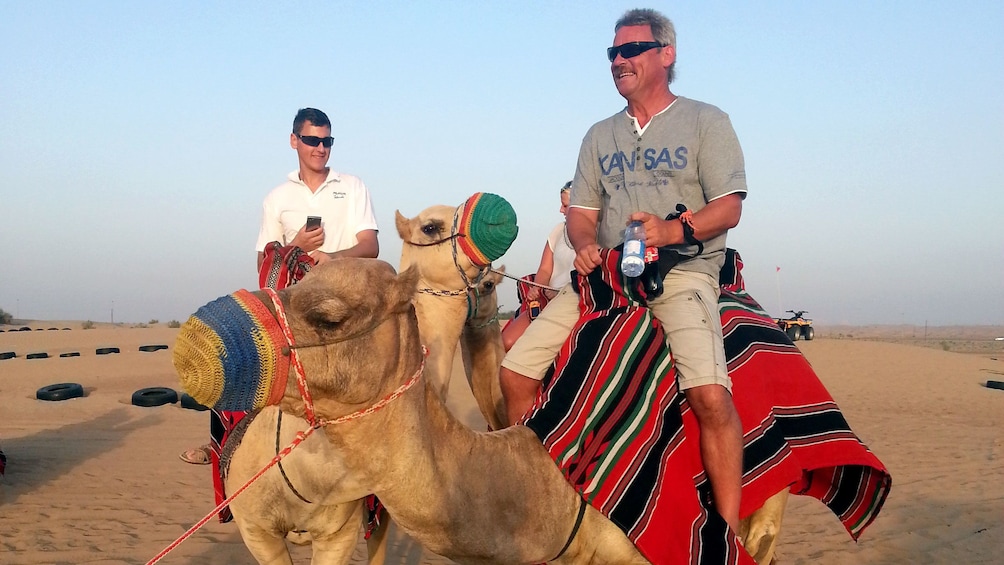 two men on camel back in Dubai
