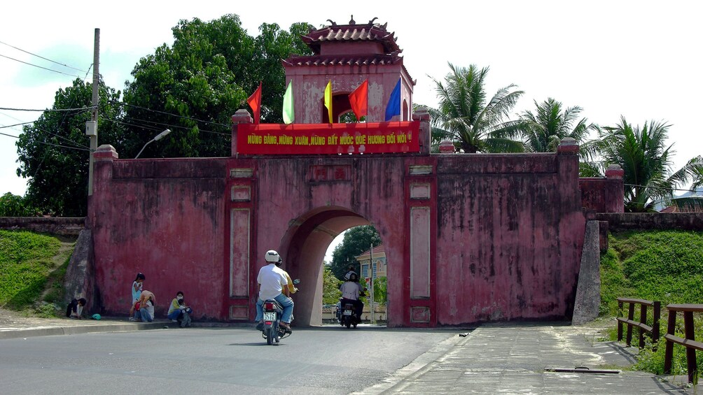 Riding scooters through a small archway in Nha Trang