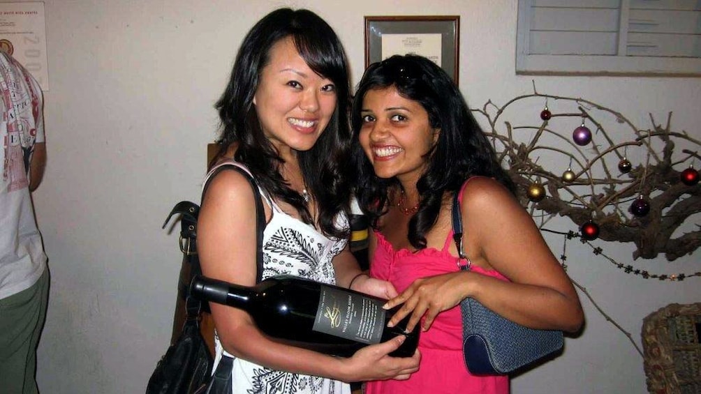 Show item 3 of 8. Pair of women with a large wine bottle at a winery in the Barossa Valley