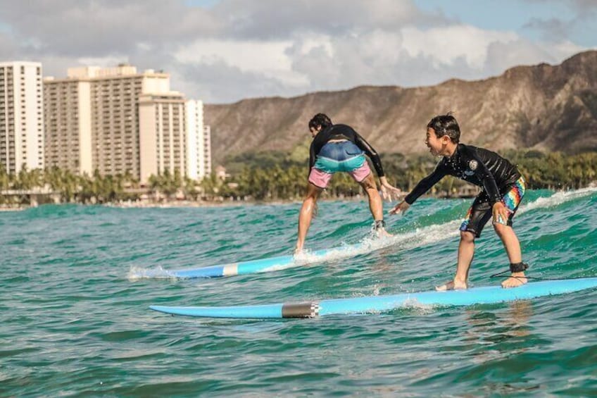 Two brothers catching a wave together on their first lesson!