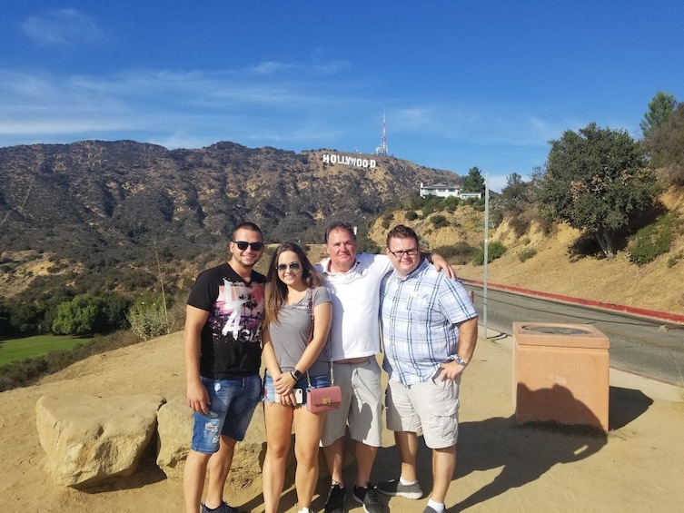Group takes photo with Hollywood sign in the background in Los Angeles 