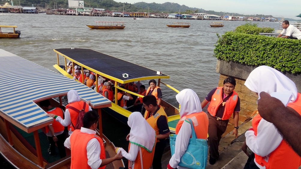 Show item 5 of 5. People getting on a tour boat in Brunei