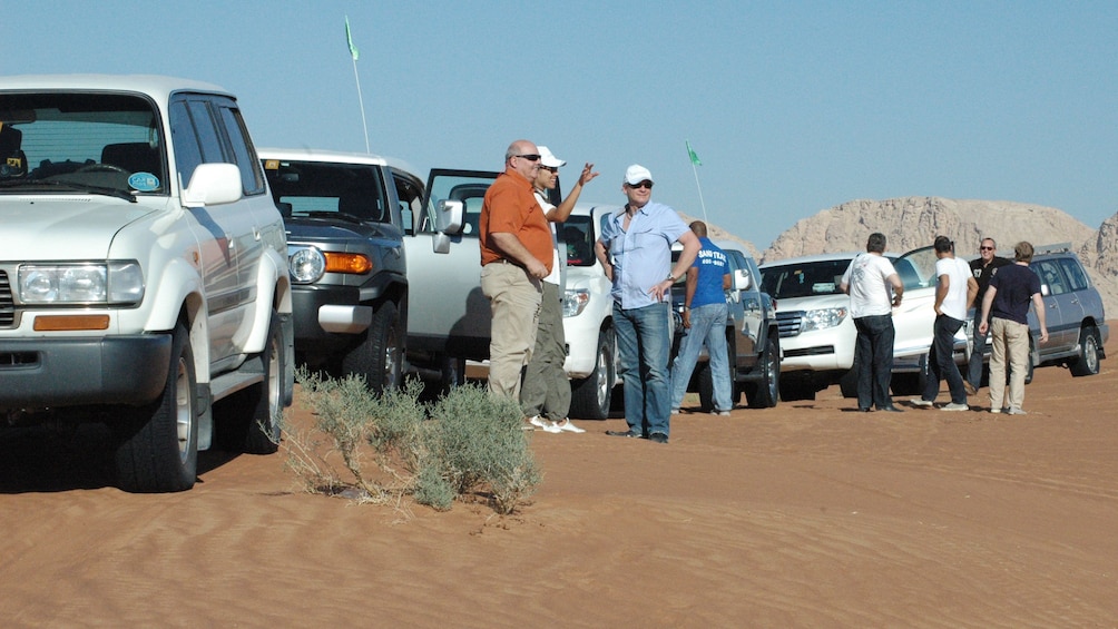 People standing outside of SUVs on tour in Dubai