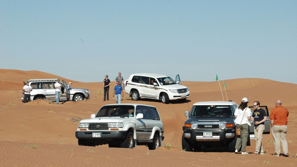 four SUVs and their passengers standing around their vehicles in Abu Dhabi