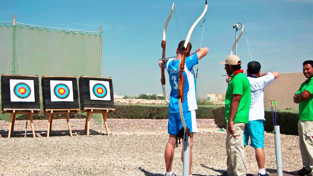 Show item 2 of 5. men at archery competition in Abu Dhabi