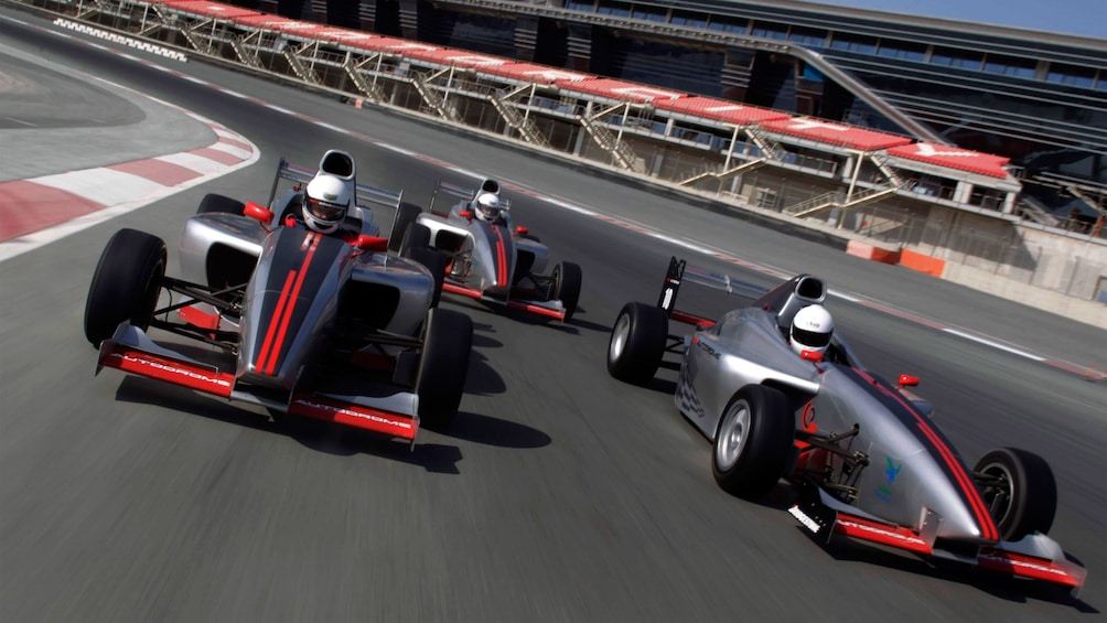 three racing cars on track in Abu Dhabi