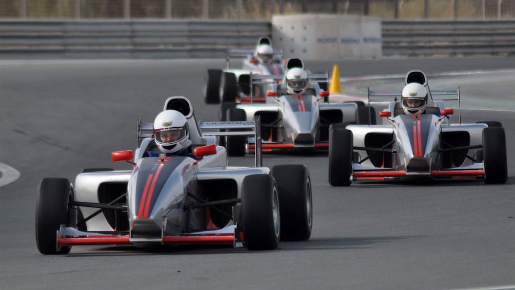 four race cars racing on track in Abu Dhabi