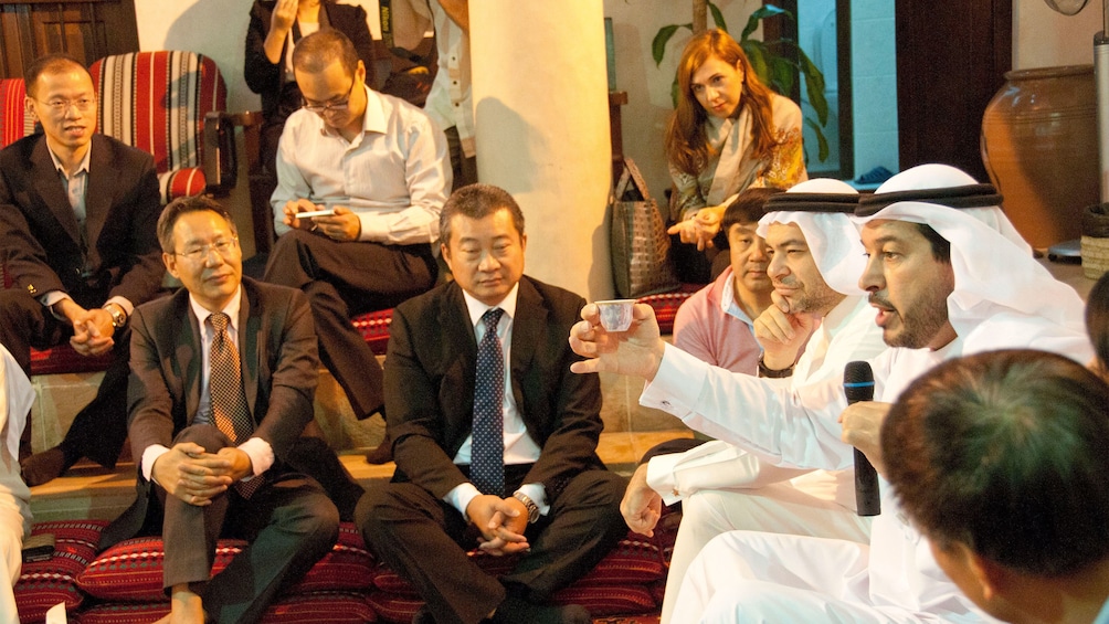 Emirati hosts raises drink to his guests in Abu Dhabi