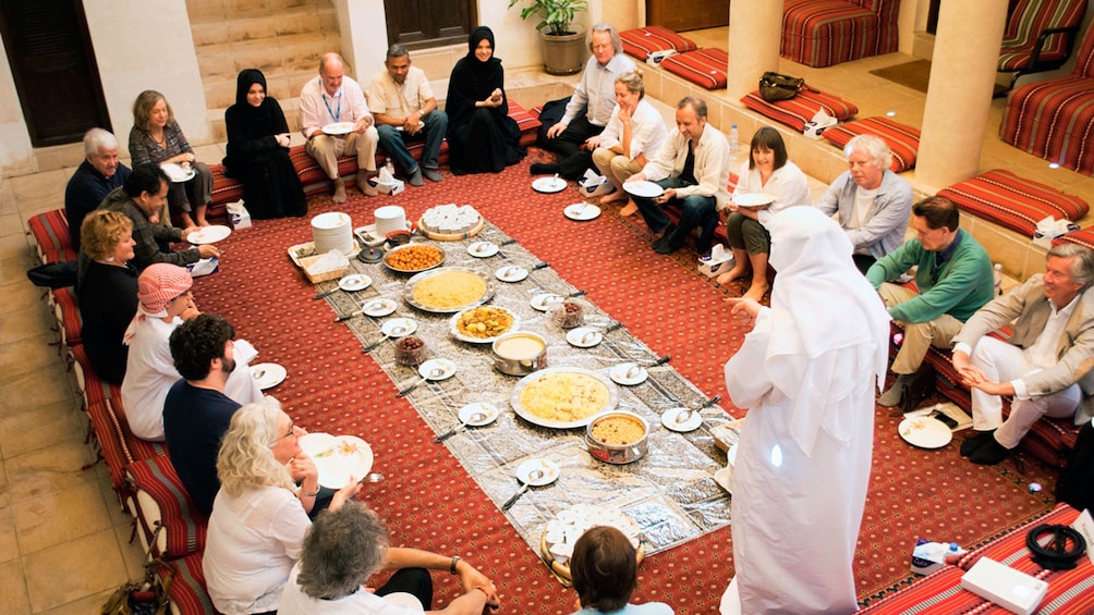 Emirati hosts stands before his guests at dinner in Abu Dhabi