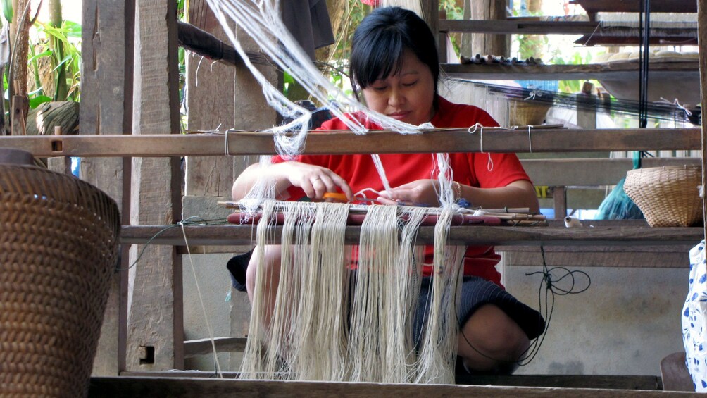 An artisan weaving on a loom in Luang Prabang