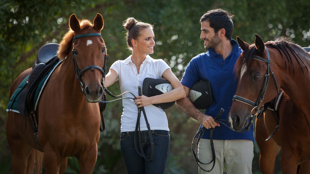 Couple walking with their horses in Dubai