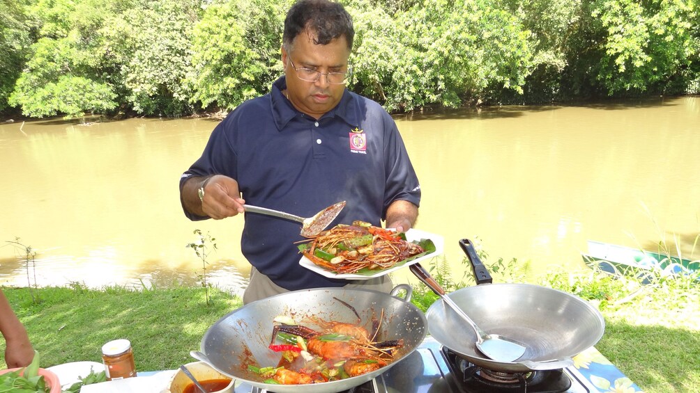 Show item 3 of 5. Man cooking meal at Ulu Temburong National Park for the tourists