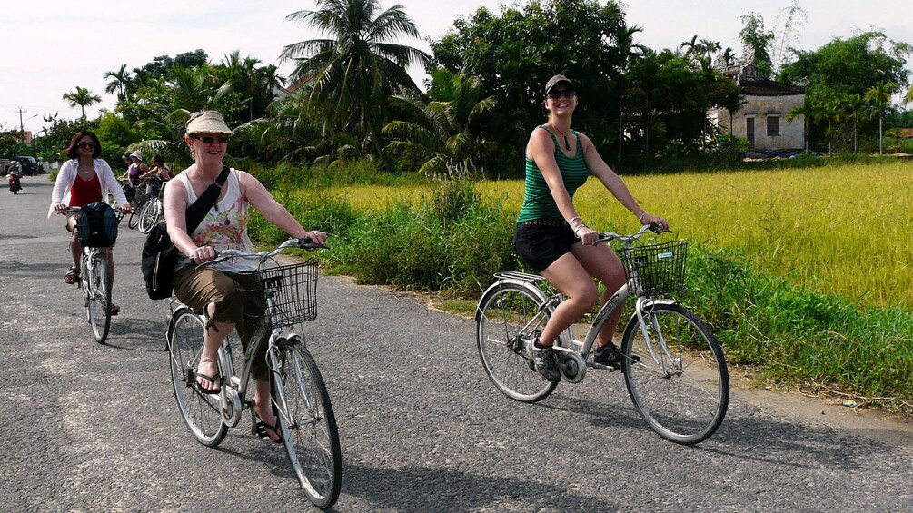 Tourists on a leisurely bike ride through bustling Hoi An and rural Tra Que in Vietnam
