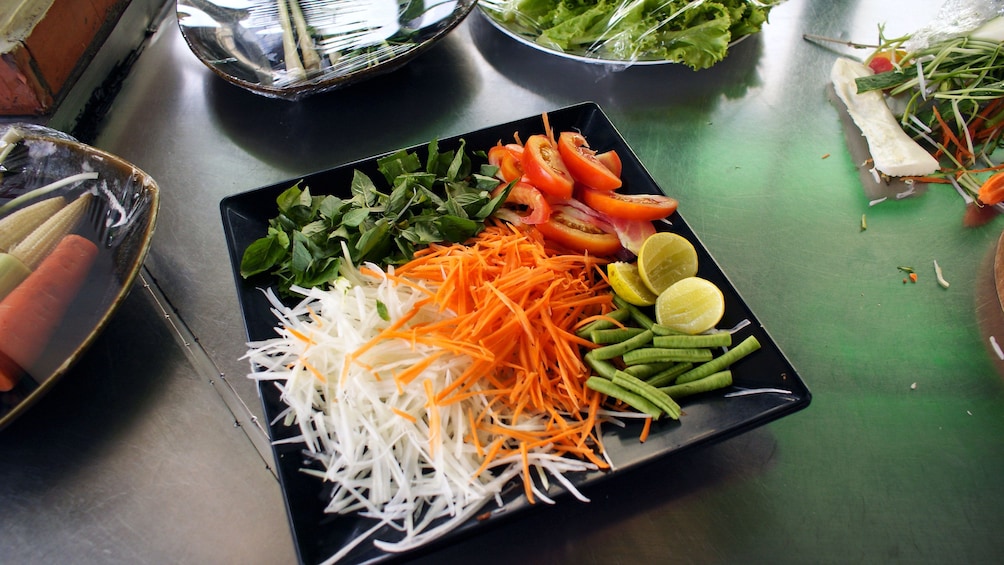 Prepared vegetables on a black dish at the  Cooking Class in Phnom Penh 