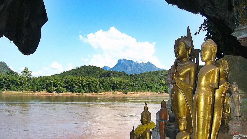 Golden buddha statues looking out the entrance to the Pak Ou Caves