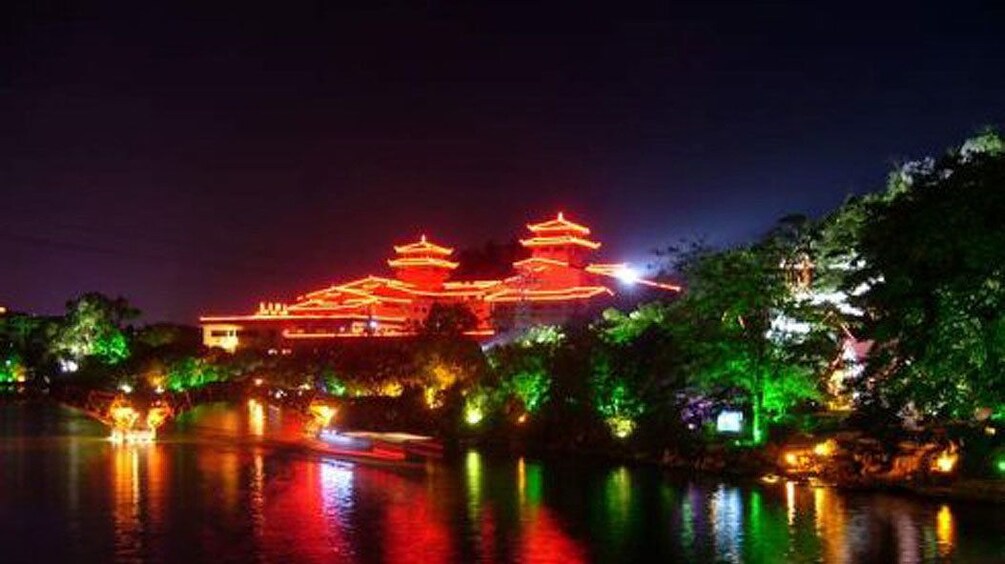 brightly lit buildings along the river in Guilin