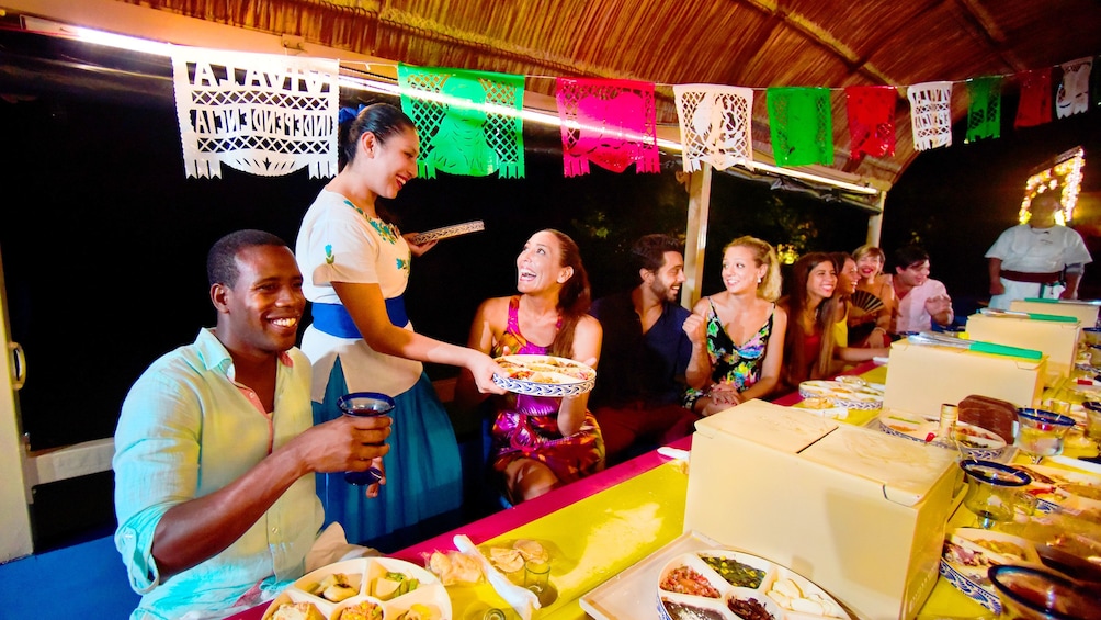 Waitress serves a table on a Mexican party boat