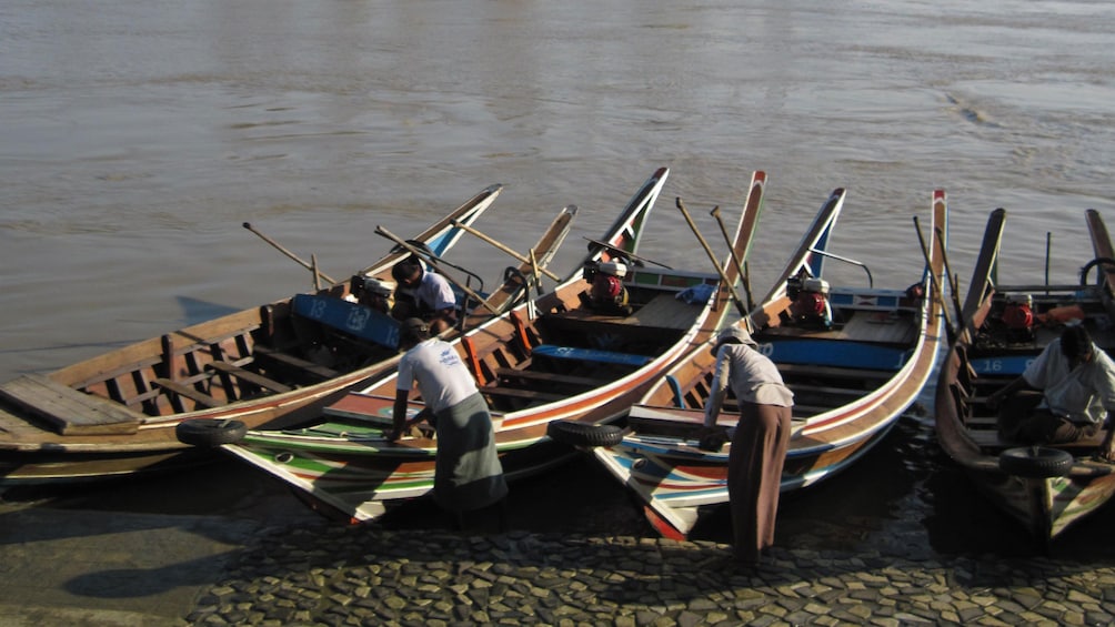 Wooden boats docked along the river's edge in Syriam