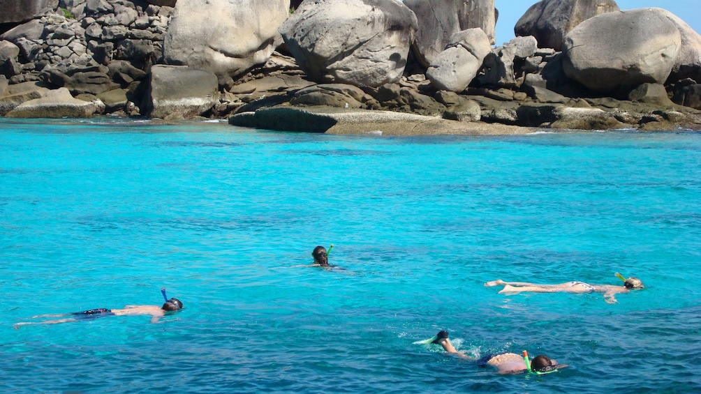 Tourists snorkeling in the waters of Similan Islands in Thailand